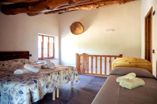 ein Schlafzimmer mit zwei Betten und Balkon in der Unterkunft I Sitoù in Ostana