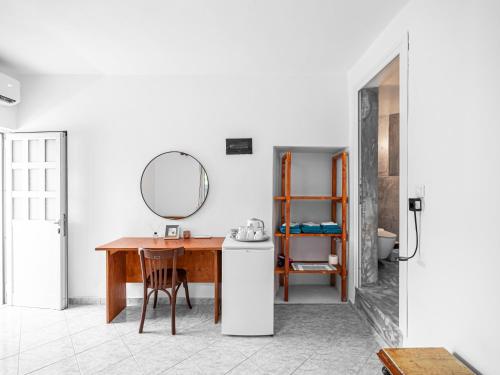 a kitchen with a table and a mirror on the wall at Bodini's Rooms in Himare