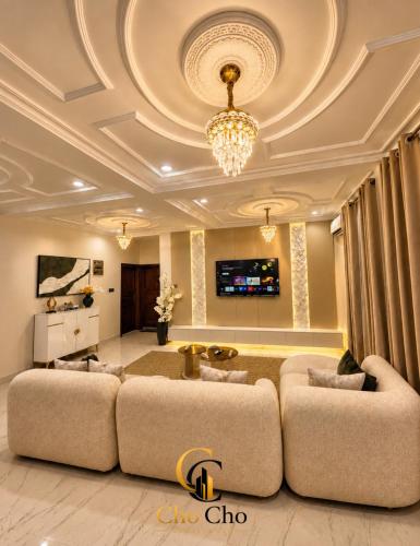 a living room with a large couch and a tv at ChoCho Apartments in Limbe