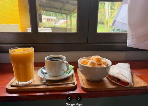 a tray with a cup of coffee and a bowl of food and a drink at Pousada Caiçara Zen in Paraty