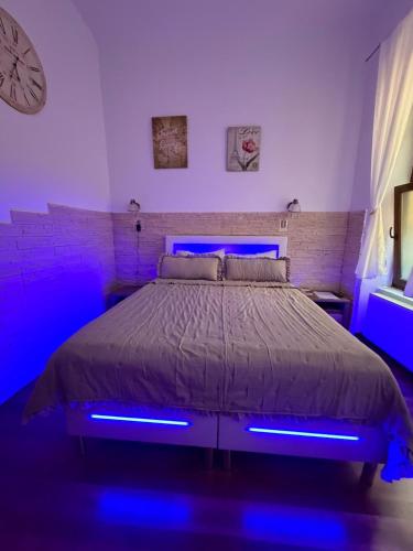sypialnia z łóżkiem z niebieskimi światłami w obiekcie Raphaela Residence w Bystrzycy