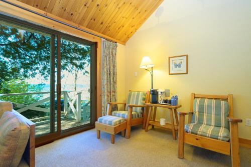 a living room with two chairs and a large window at 148 Divot Simcoe Cottage private Beach, Kayak in Georgina