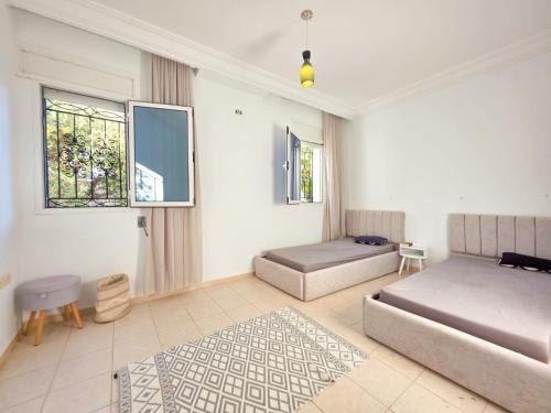 a bedroom with two beds and a rug at Villa Safiya in Djerba