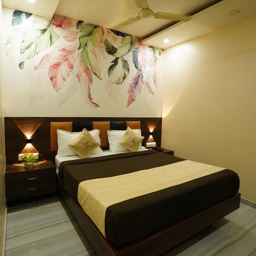 a bedroom with a bed with a painting on the wall at Hotel Royce By Glitz-Nxt to Visa Consulate & Kurla Station in Mumbai