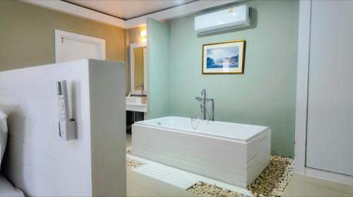 a bathroom with a white tub and a sink at Bann Sunset Cove Krabi I A Hidden Luxury Escape on Had Yao Beach in Krabi