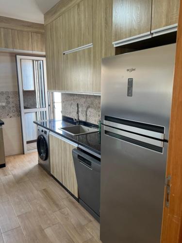 a kitchen with a stainless steel refrigerator and a dishwasher at Jad Moon Stay in Fnidek