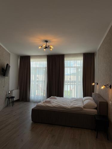 a bedroom with a large bed and two windows at Старий Дуб in Mizhhirya