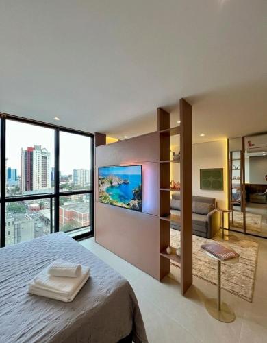 a bedroom with a large bed and a large window at Neo House in Maringá