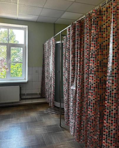 a bathroom with a shower with curtains and a window at Spāres muiža in Spāres Muiža