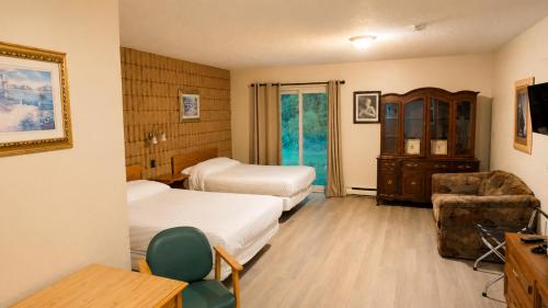 a hotel room with two beds and a chair at Top Notch Motel in Wiarton