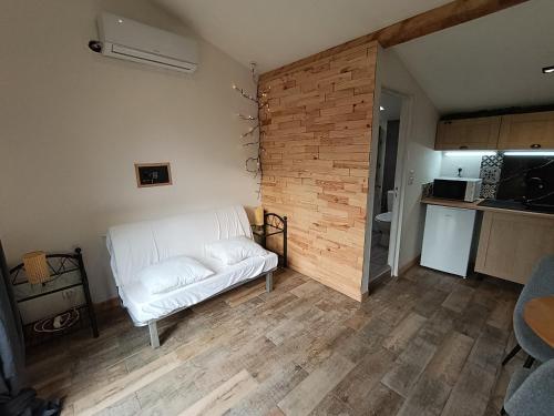 a living room with a white couch and a brick wall at Dax Jardin Studio in Dax