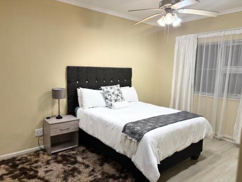 a bedroom with a bed and a ceiling fan at 35 Quanza in East London