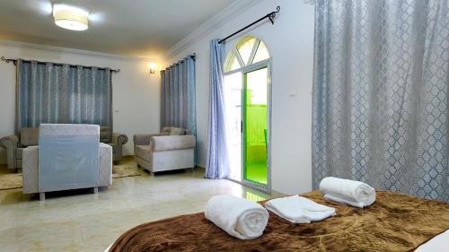a bedroom with a bed and a living room with a window at Hôtel Résidence le Berger in Nouakchott