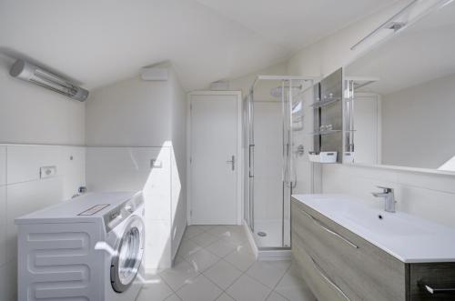 a white bathroom with a washing machine and a sink at Villa dante in Alba