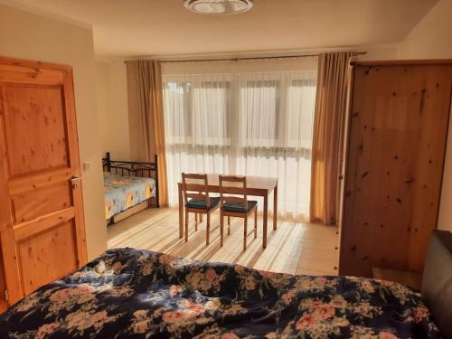 a bedroom with a bed and a table and chairs at Ferienwohnung Lilie in Pegau