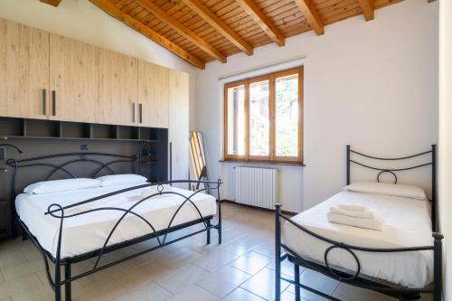 a bedroom with two beds and a window at Mirafiume - Lugano Lake in Valsolda