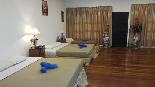 a hotel room with three beds and blue pillows at Crystal Hill R in Kundasang