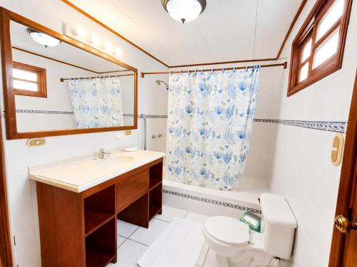 a bathroom with a sink and a toilet and a mirror at Hotel Gracia in San Juan del Sur
