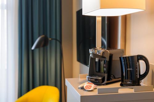 a coffee cup sitting on top of a counter next to a lamp at Mercure Berlin Wittenbergplatz in Berlin
