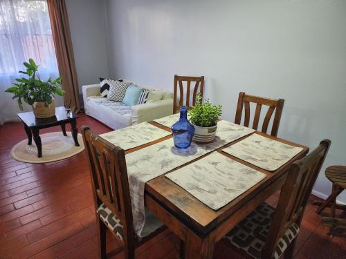 a dining room with a table with chairs and a couch at Casa Runa in Quillota