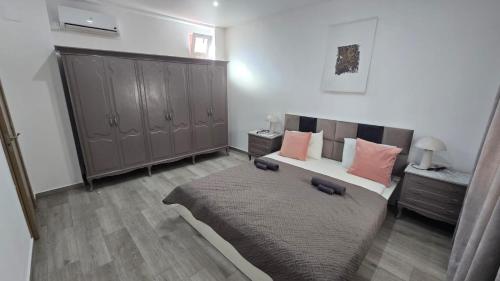 a bedroom with a large bed with pink pillows at Casa NOU in Cullera