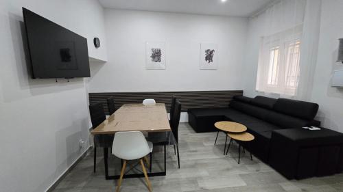 a living room with a black couch and a table at Casa NOU in Cullera