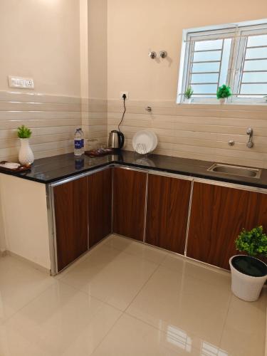 a kitchen with wooden cabinets and a counter top at Palazhi Stay 160m from Guruvayur Temple in Guruvāyūr