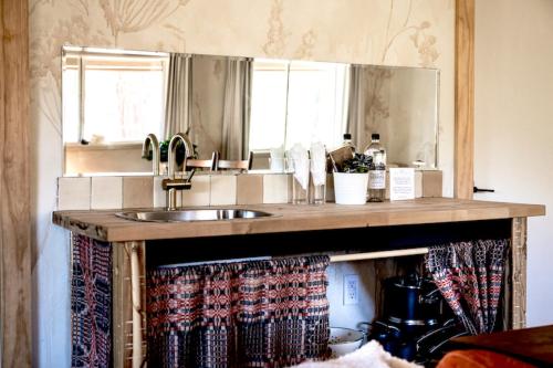 a kitchen counter with a sink and a mirror at Designer King Studio Private Curated Cottage in Cottonwood