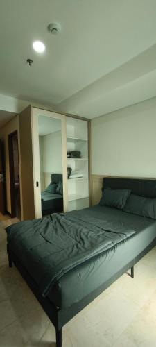 a bedroom with a large bed with a large mirror at Smart Studio - BResidences ICE BSD in Tjilandak