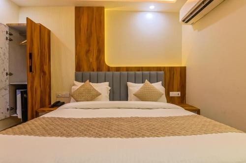 a bedroom with a large bed with white sheets and pillows at Hotel Shivmurti Temple Palace By G K Group in Varanasi