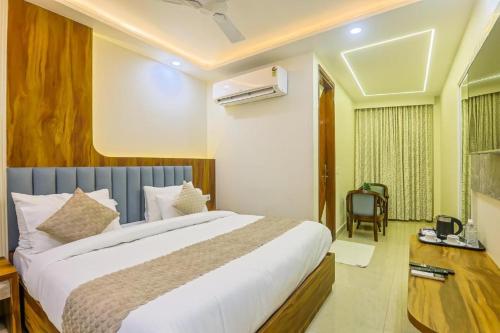 a bedroom with a large bed and a desk at Hotel Shivmurti Temple Palace By G K Group in Varanasi