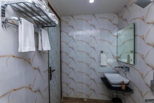 a bathroom with a sink and a mirror at Hotel Shivmurti Temple Palace By G K Group in Varanasi