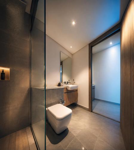 a bathroom with a toilet and a sink at Ajmal Villa in Al Ḩamrīyah