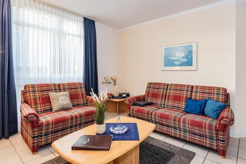 a living room with two couches and a table at Haus Roland, Wohnung 04 in Zinnowitz