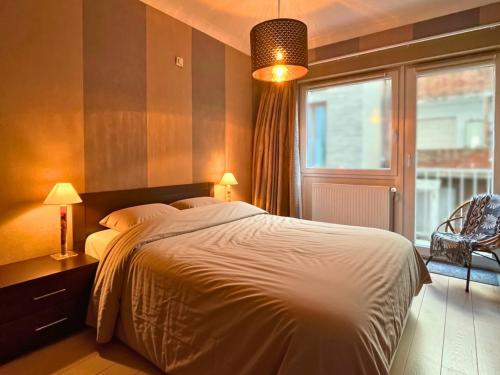 a bedroom with a large bed and a window at Le Channel - Parenthèse calme face à la mer sur la digue - Idéal famille - Équipements bébé - Ascenseur in Koksijde