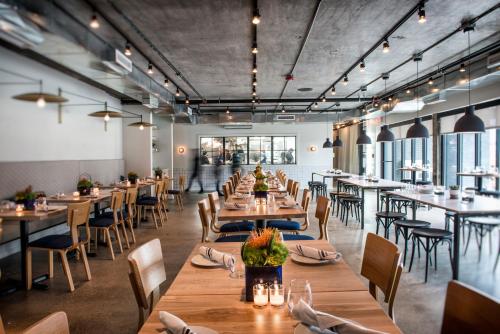 a restaurant with wooden tables and chairs and windows at Trumbull and Porter - Detroit Downtown in Detroit