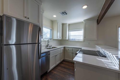 a kitchen with a stainless steel refrigerator and white cabinets at Park Street Apartment - Front Unit in Paso Robles