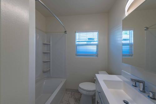 a white bathroom with a toilet and a sink at Park Street Apartment - Front Unit in Paso Robles