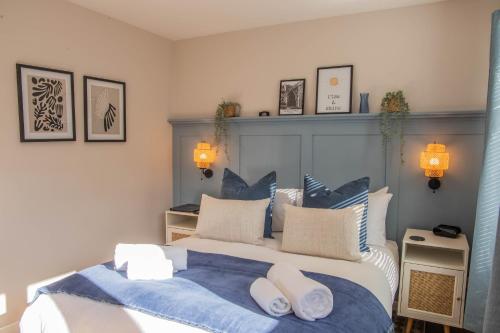 a bedroom with a large bed with blue and white pillows at Bridgeside Rooms in Ironbridge
