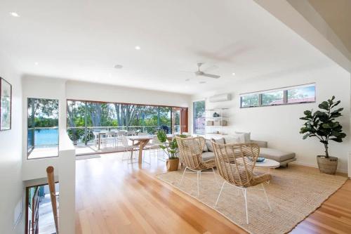 a living room with a couch and a table and chairs at Tranquil & Modern Riverside Getaway in Noosaville