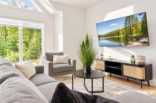 a living room with a couch and a tv on a wall at Spa - River - Game Room - Le Boreal in Mont-Tremblant