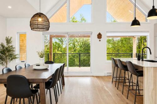 a kitchen and dining room with a wooden table and chairs at Spa - River - Game Room - Le Boreal in Mont-Tremblant