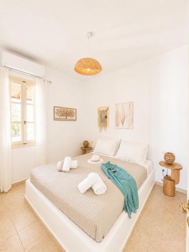 a white bedroom with a large bed with towels on it at Uranos studios Amorgos in Amorgos