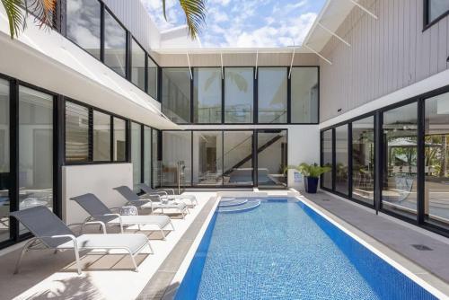 an empty house with a swimming pool and windows at Luxury Retreat with Private Beach & Jetty in Noosa Heads