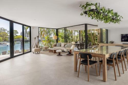 a living room with a glass table and chairs at Luxury Retreat with Private Beach & Jetty in Noosa Heads