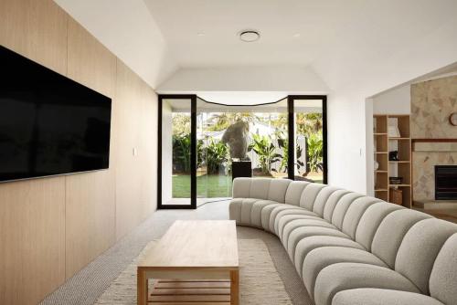 a living room with a large couch and a tv at Casa Six on Witta in Noosa Heads