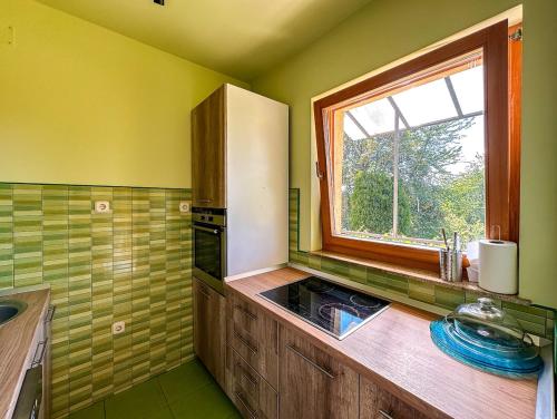 a kitchen with a white refrigerator and a window at Papa's Hideout Sarajevo in Buhotina