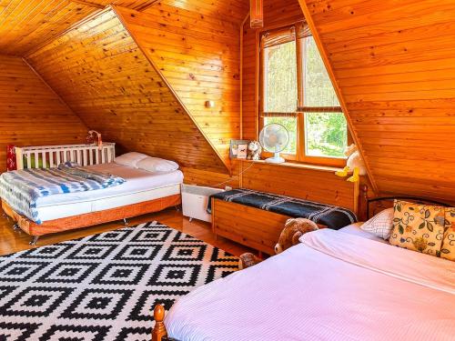 a bedroom with two beds in a log cabin at Papa's Hideout Sarajevo in Buhotina