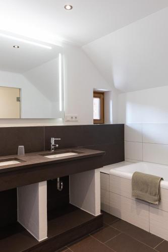 a bathroom with a sink and a large mirror at Alpen Chalet Forest in Mauterndorf