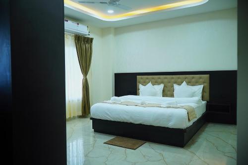 a bedroom with a large bed with white sheets at Hotel Delw in Bacha